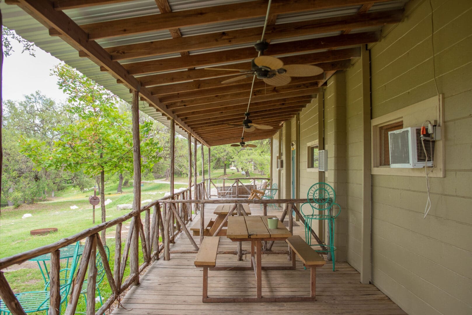 A porch with benches and tables on it