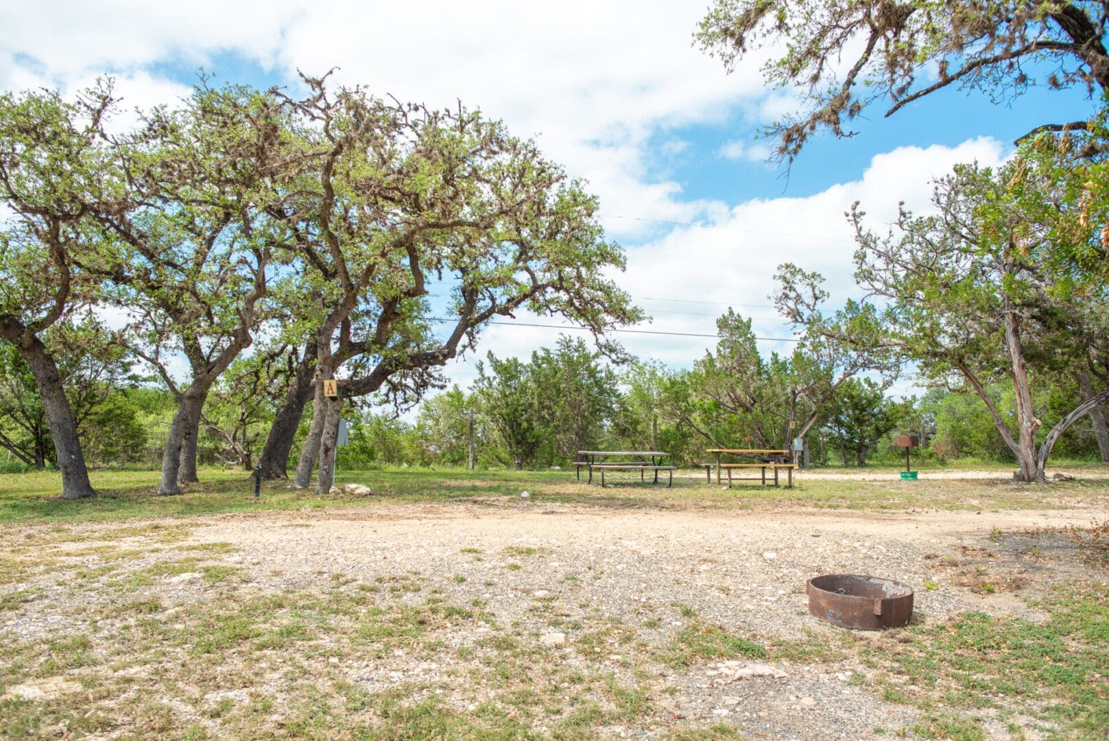 A picnic table and bench in the middle of an empty field.