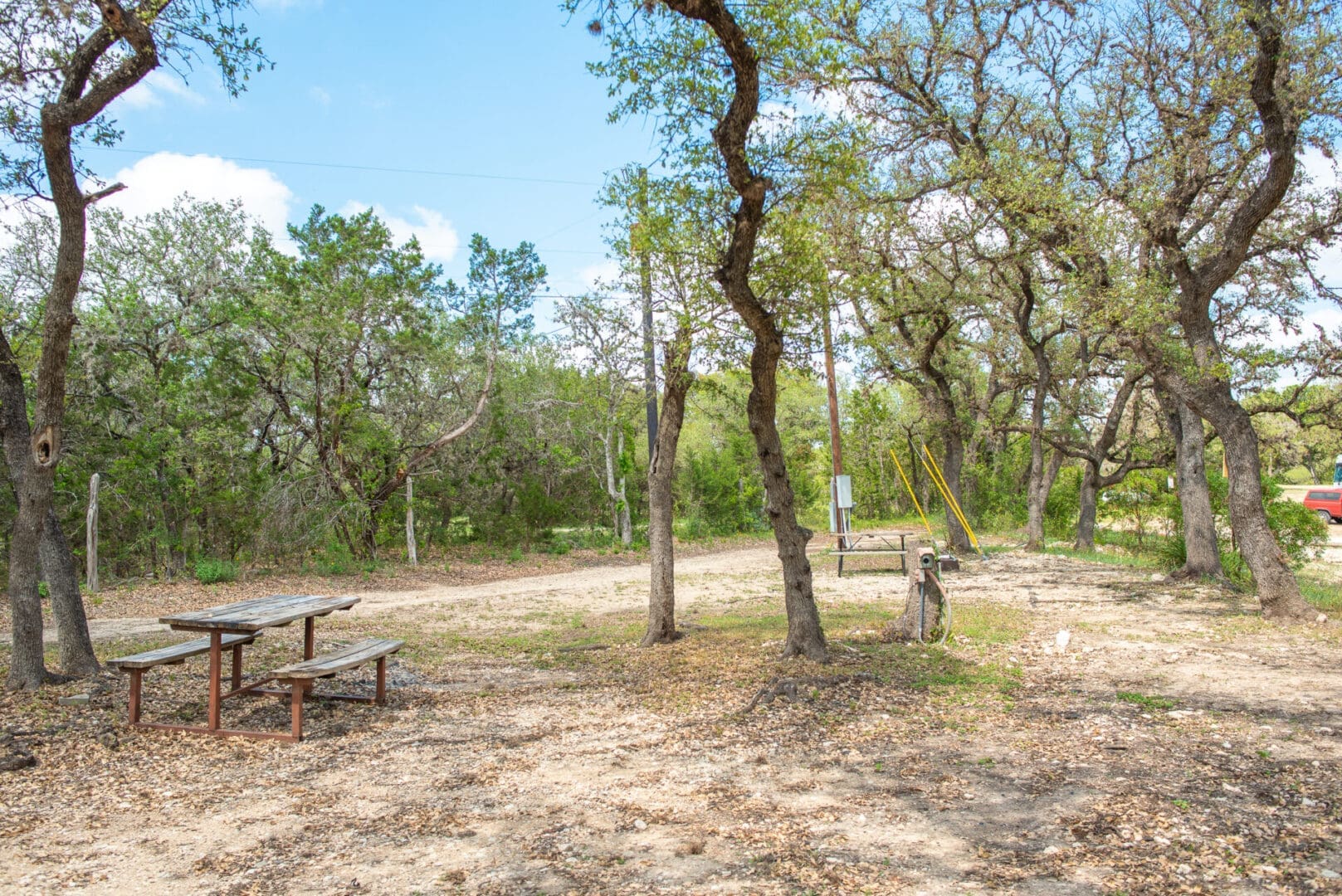 A picnic table and bench in the middle of an area.