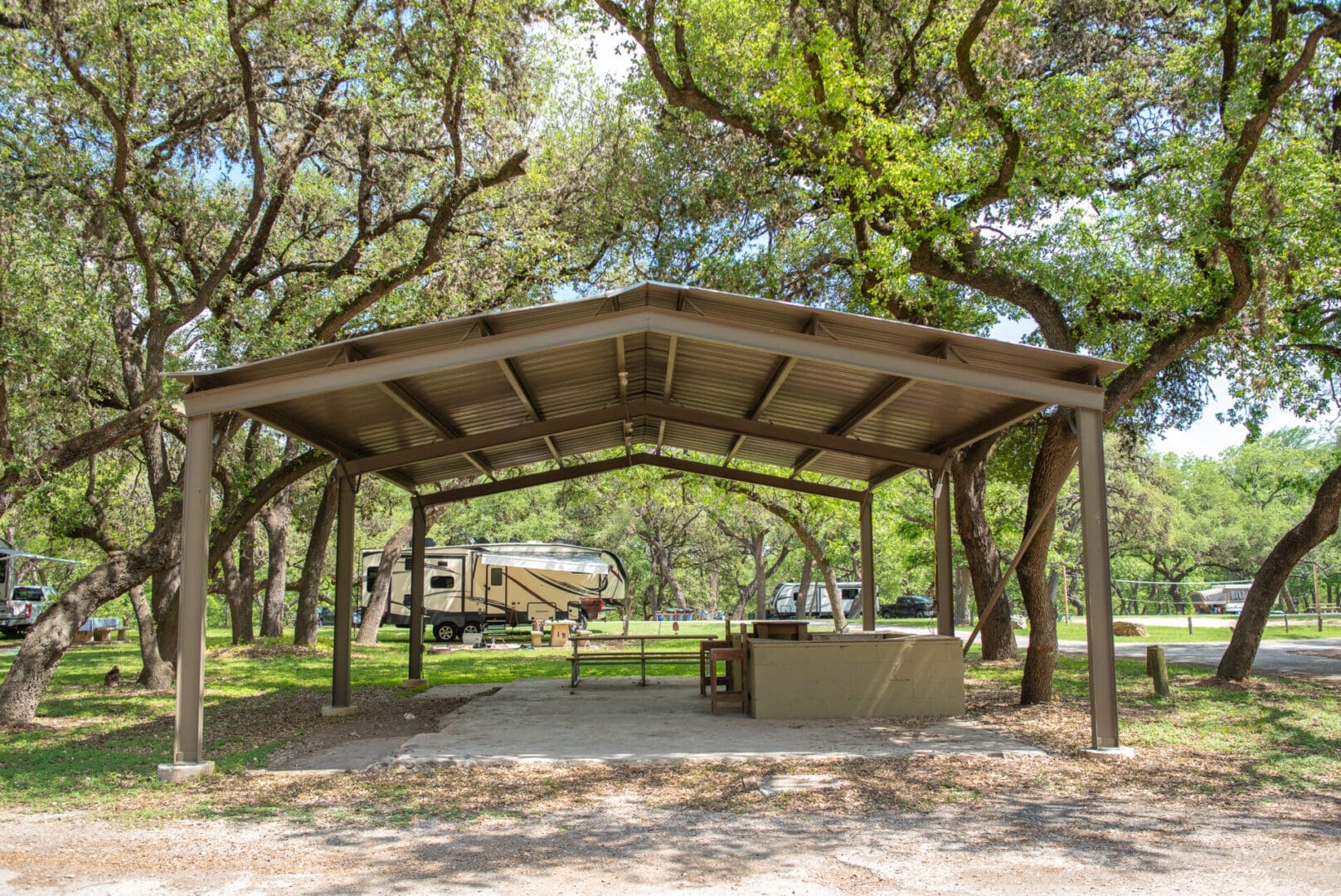 A covered area with trees and a truck in the background.