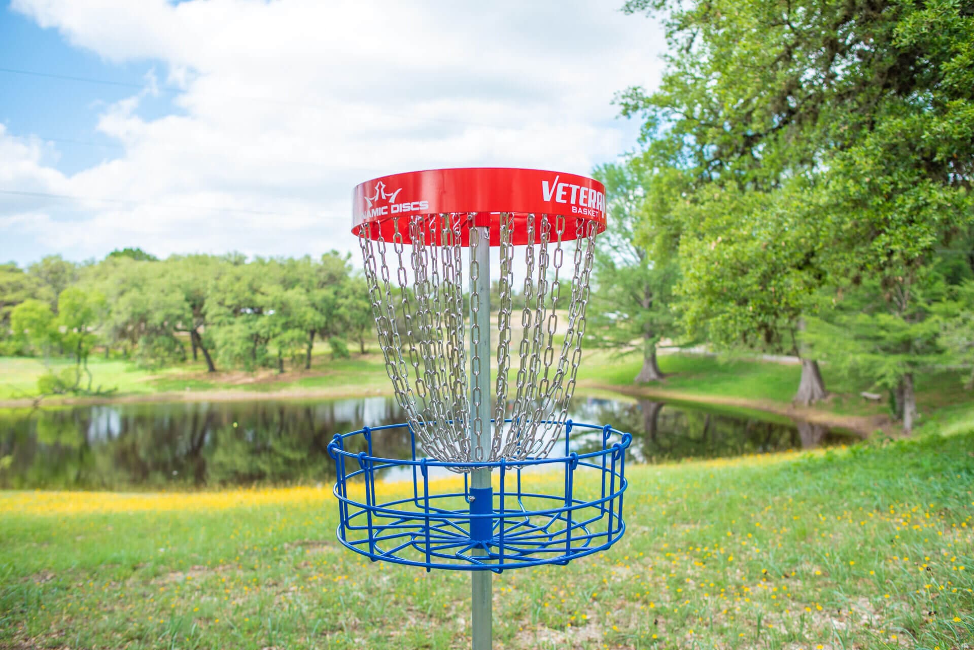 A frisbee golf basket in the middle of a field.