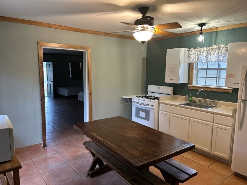 A kitchen with an oven, sink and table.