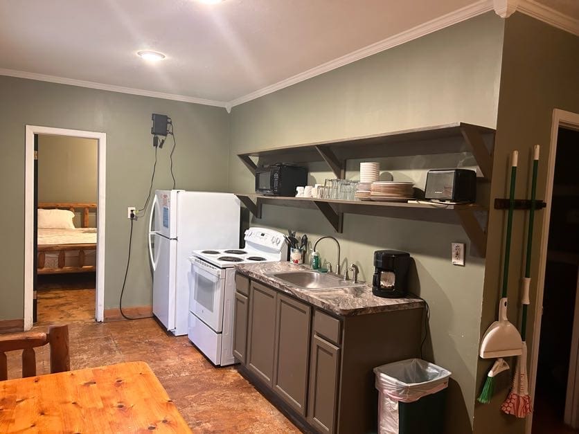 A kitchen with a sink, refrigerator and microwave.