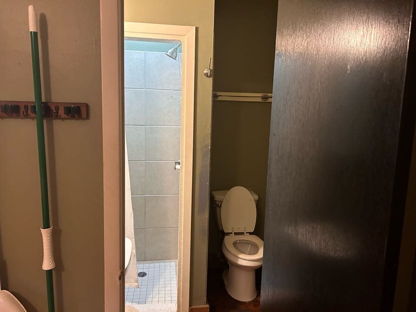 A bathroom with a toilet and shower stall.