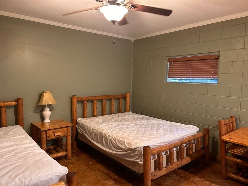 A bedroom with two beds and a lamp on the table.