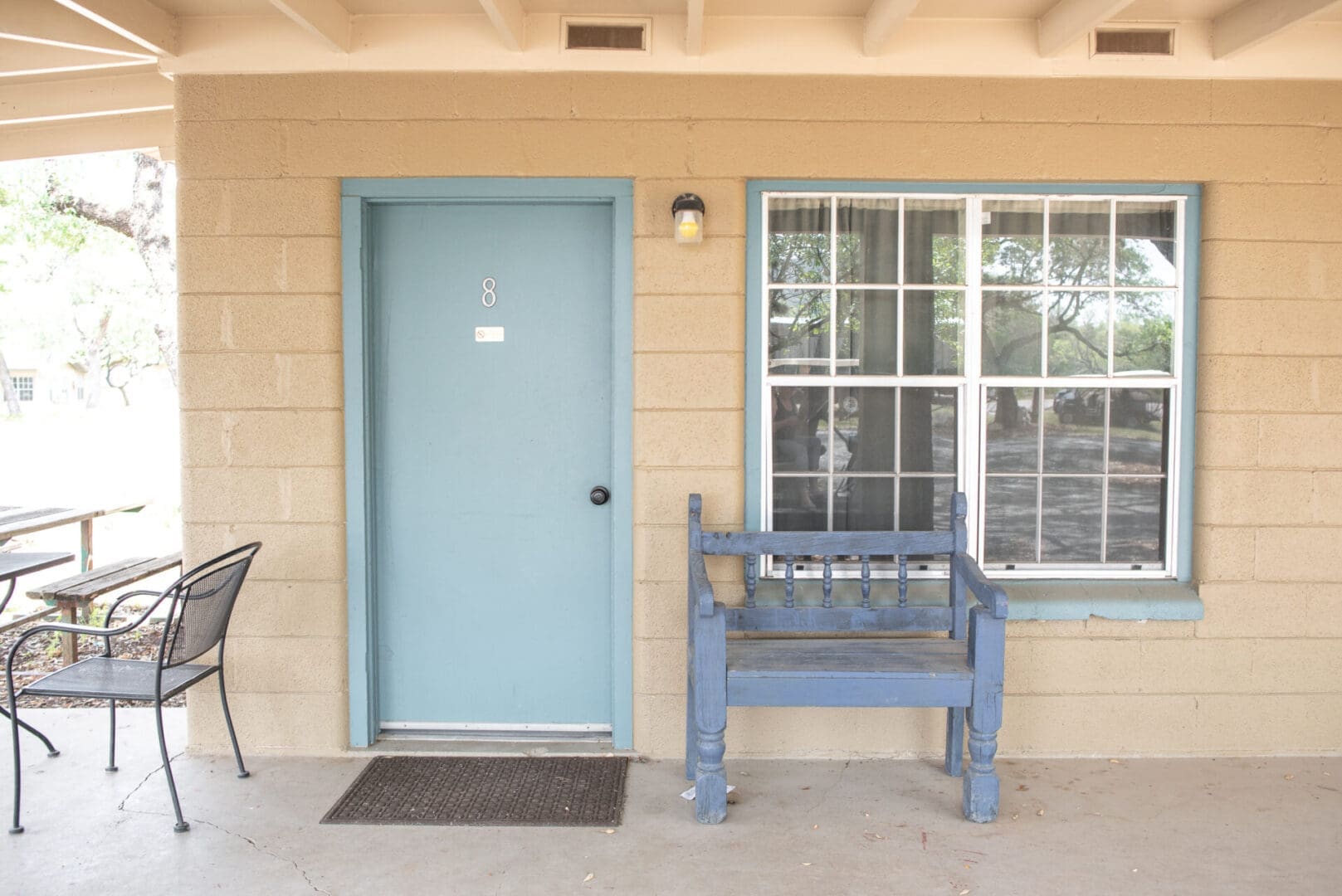 Blue door and bench outside motel room.