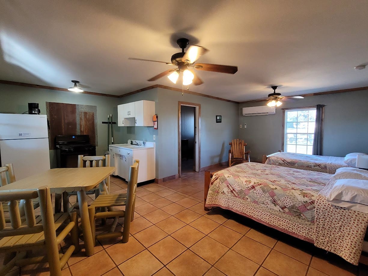 Cabin interior with kitchen and beds.