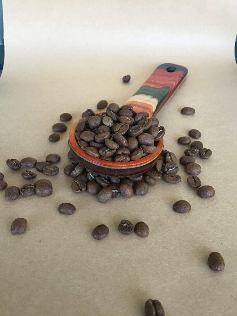 Coffee beans in a wooden spoon.