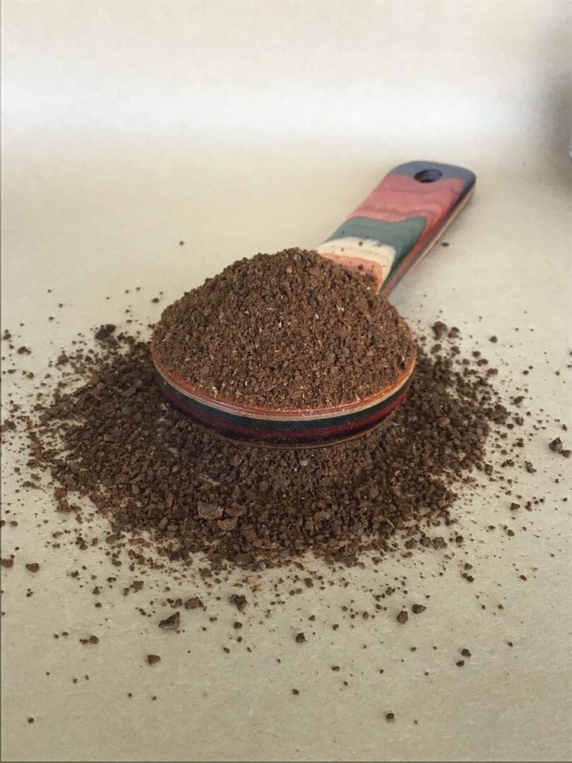 Ground coffee in a colorful spoon.